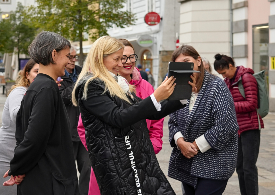 Frauen machen ein Selfie in der Stadt, lächelnd und fröhlich.