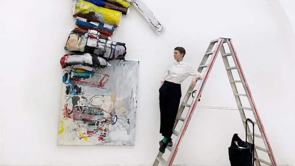 The artist Olga Shcheblykina on the ledder in front of her art