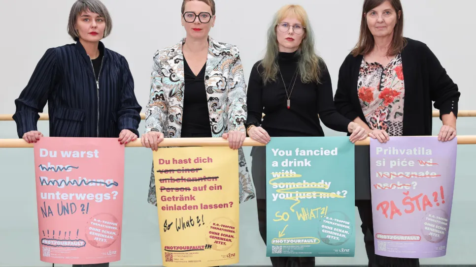 Vier Frauen halten bunte, feministische Plakate mit Botschaften.