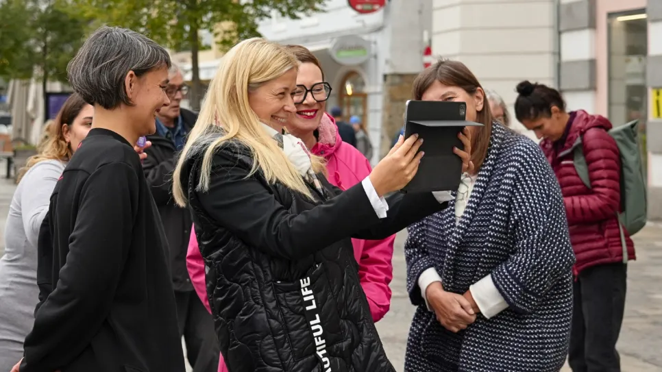 Frauen machen ein Selfie in der Stadt, lächelnd und fröhlich.