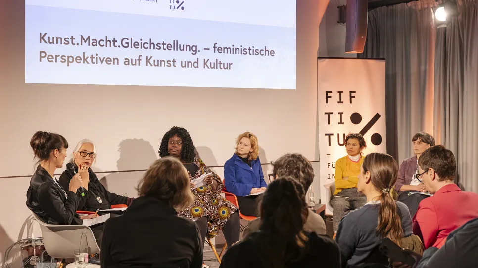 Podiumsdiskussion über feministische Perspektiven in Kunst und Kultur mit mehreren Teilnehmern.