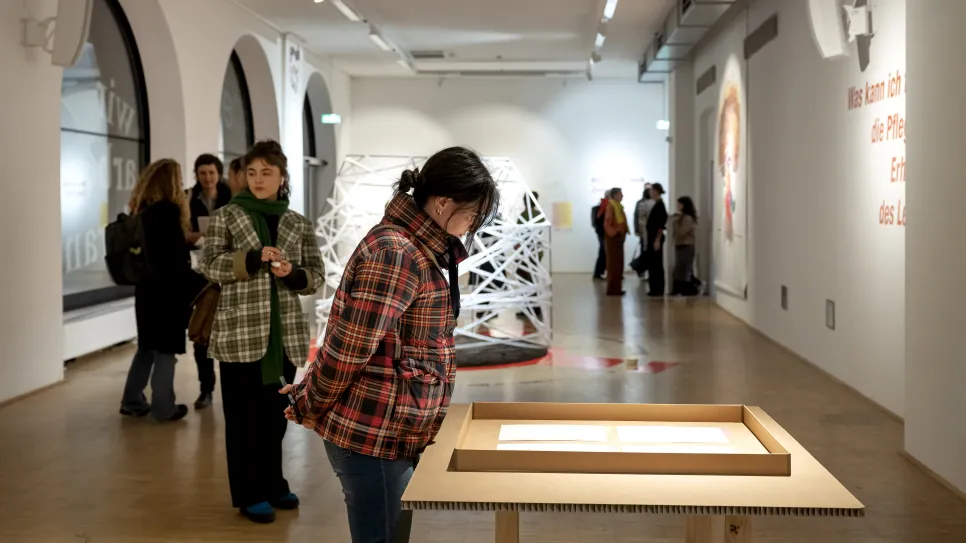 Menschen betrachten Kunst in einer Galerieausstellung.