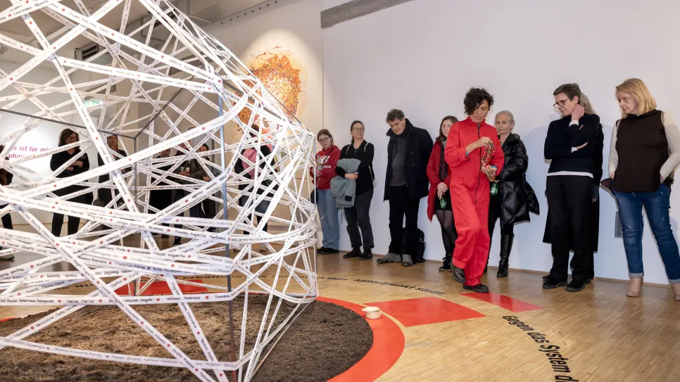 Besucher betrachten moderne Skulptur in Galerieumgebung.