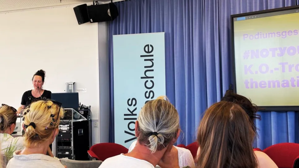 Eine Frau spricht vor Publikum, Slide mit Text "#NOTYOURK.O.-Tropfen" im Hintergrund.