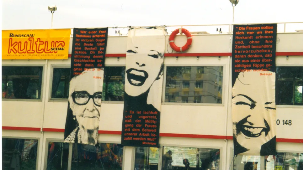 Fassade mit feministischen Bannern und gelbem Kulturlogo.