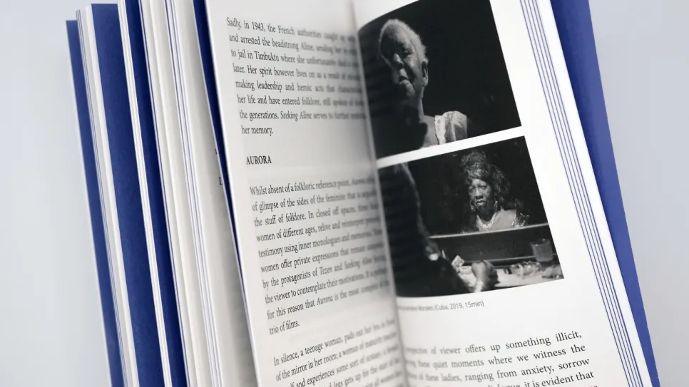 Offenes Buch mit Text und zwei Fotos von Personen in Schwarz-Weiß.