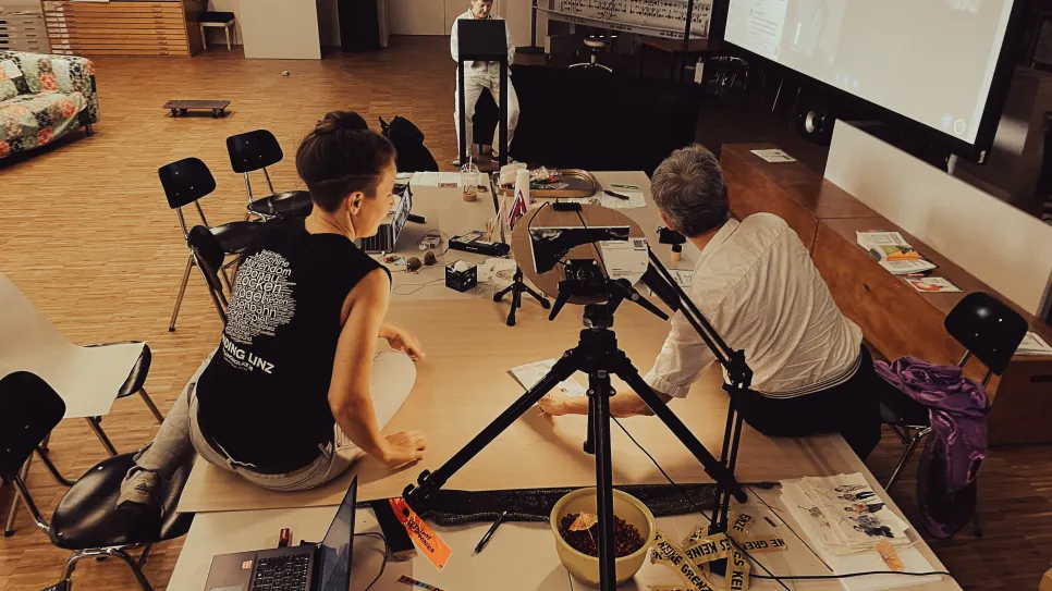 Personen bei Workshop mit Laptop und Leinwand im Raum.