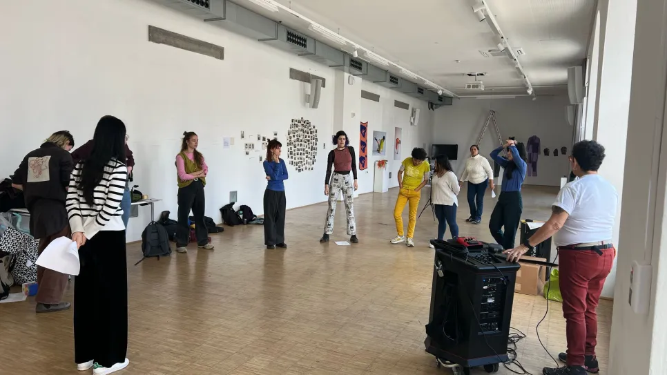 Menschen in Workshop, helle Galerie, entspannte Atmosphäre.