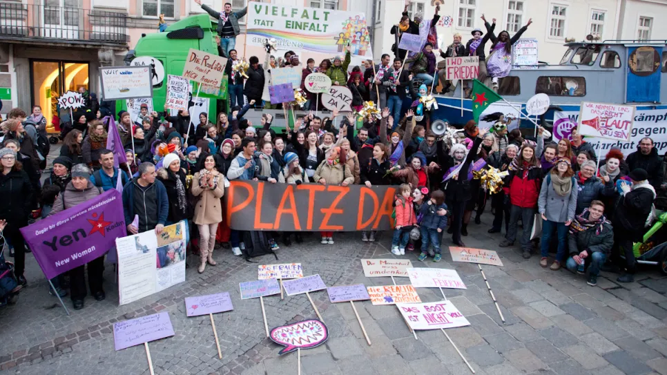 Gruppenfoto einer feministische Versammlung mit Plakaten und Transparenten.