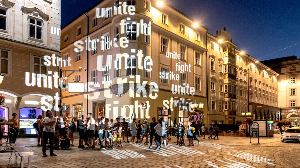 Historische Gebäude bei Nacht, Projektion mit „unite, strike, fight“.