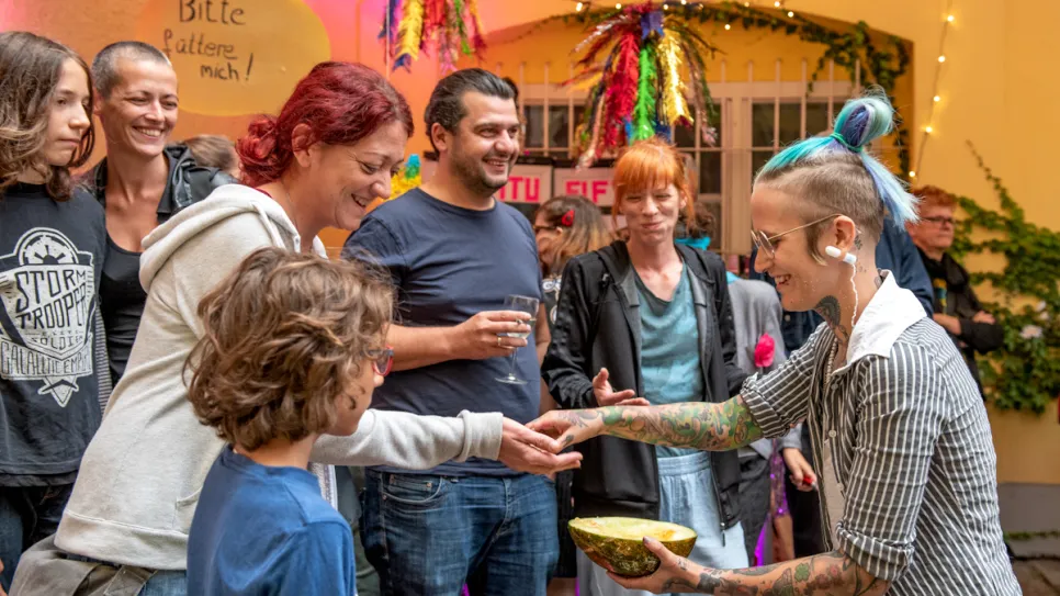 Menschen lächeln und interagieren bei einem bunten Fest mit Lichtern.
