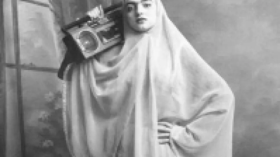 Eine Frau in traditioneller Kleidung hält ein Radio.
