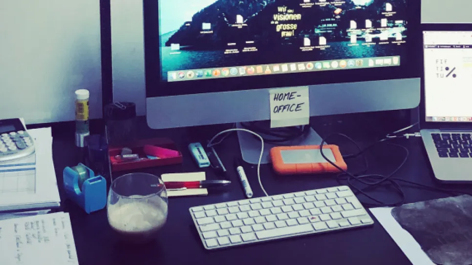Arbeitsplatz mit zwei Computern, Tastatur, Maus und Unterlagen.
