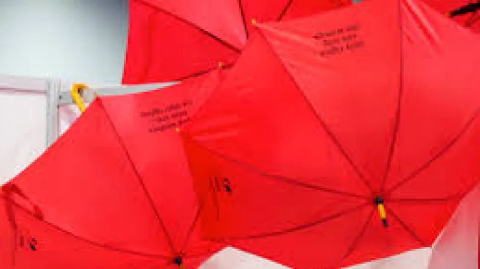 Rote Regenschirme hängen an einer Decke.