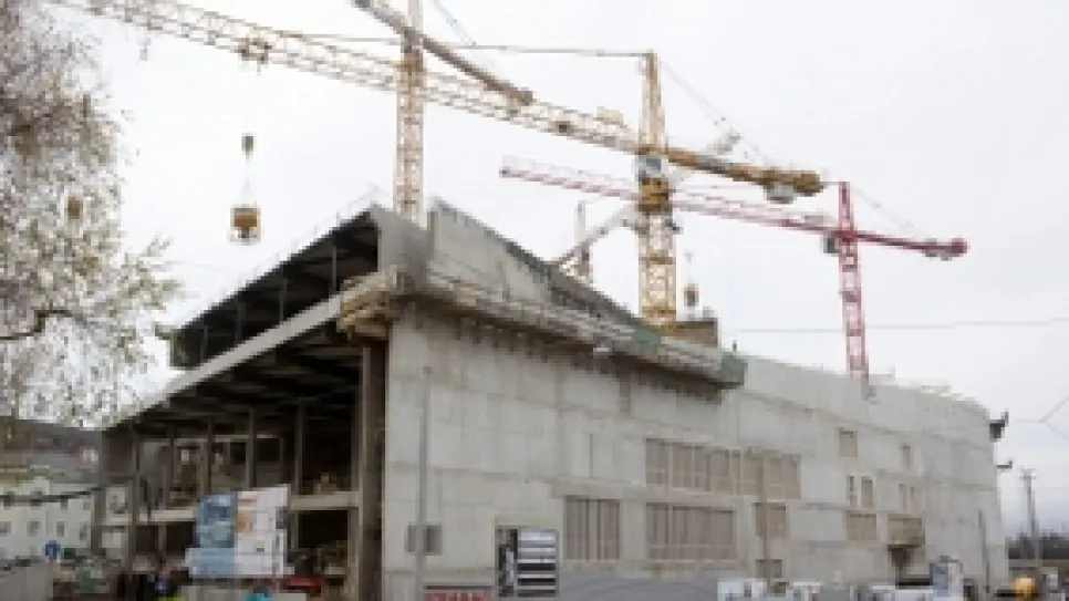 Bau einer großen Betonstruktur mit zwei Kränen.
