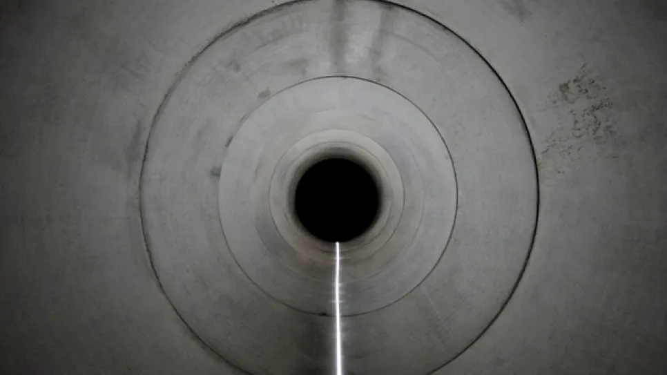 Blick in einen beleuchteten Betontunnel mit konzentrischen Kreisen.