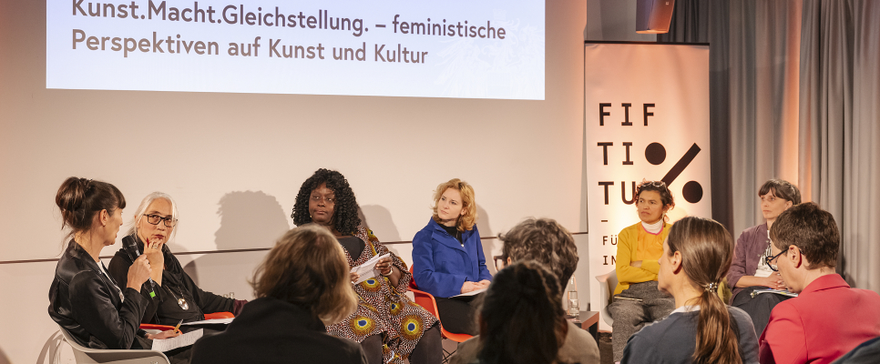 Podiumsdiskussion über feministische Perspektiven in Kunst und Kultur mit mehreren Teilnehmern.