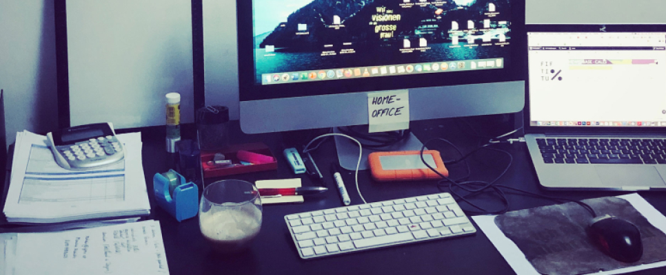 Arbeitsplatz mit zwei Computern, Tastatur, Maus und Unterlagen.