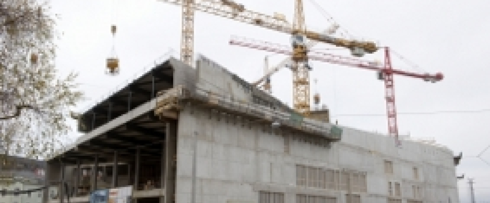 Bau einer großen Betonstruktur mit zwei Kränen.