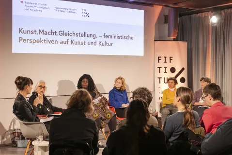 Podiumsdiskussion über feministische Perspektiven in Kunst und Kultur mit mehreren Teilnehmern.