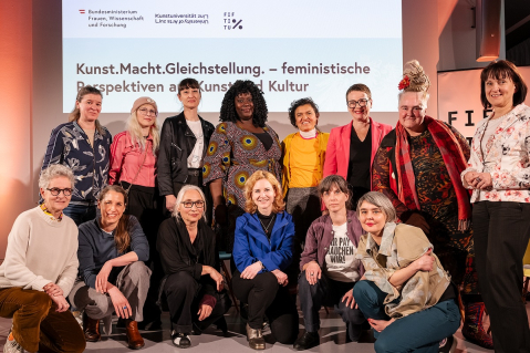 Gruppe von Frauen vor einem Banner mit dem Titel "Kunst. Macht. Gleichstellung."