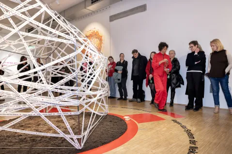 Besucher betrachten moderne Skulptur in Galerieumgebung.