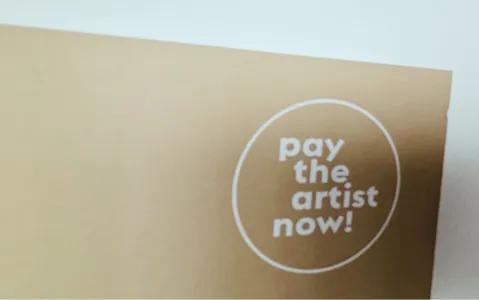 Beiges Plakat mit dem Text "pay the artist now!" in einem weißen Kreis.