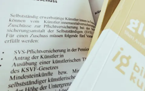 Broschüre mit Text über Künstlersozialversicherung, Teil eines Logos sichtbar.