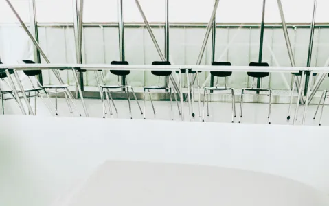 Leere Konferenzstühle in modernem Raum mit Glaswänden.