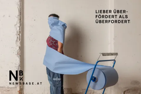 Person in blauer Papierrolle gewickelt, daneben Slogan "Lieber über-fördert als überfordert".