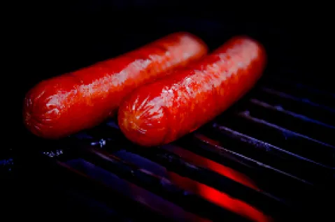 Zwei gegrillte Würstchen auf einem dunklen Grillrost.