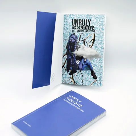 Offenes Buch und Heft mit blauem Einband auf hellem Hintergrund.