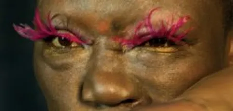 Rotes, federartiges Make-up an den Augen einer Person, Nahaufnahme.
