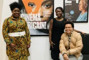 Three persons from cinema world are standing in front of the poster.