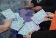 Flyer in Händen mehrerer Personen, Fokus auf Texte über feministische Forderungen.