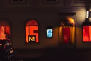 Gebäude bei Nacht mit oranger Beleuchtung und Schaufenstern zu den 16 Tagen gegen geschlechterspezifische Gewalt