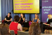 Podiumsdiskussion über K.O.-Tropfen in Linz, vier Frauen sprechen vor gelbem Banner.