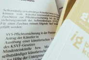 Broschüre mit Text über Künstlersozialversicherung, Teil eines Logos sichtbar.