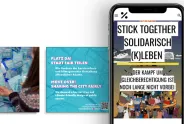 Smartphone mit feministischen Postern, Text: "Stick Together Solidarisch (K)leben."