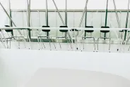 Leere Konferenzstühle in modernem Raum mit Glaswänden.