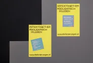 Gelbe Plakate mit Text, Hashtags und Website auf grauem Hintergrund.