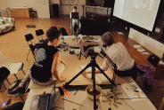 Personen bei Workshop mit Laptop und Leinwand im Raum.