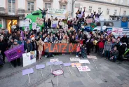 Gruppenfoto einer feministische Versammlung mit Plakaten und Transparenten.
