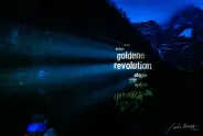 Lichtprojektion von Worten auf Bergkulisse bei Nacht.