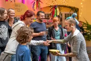 Menschen lächeln und interagieren bei einem bunten Fest mit Lichtern.