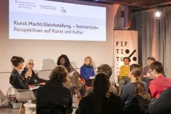 Podiumsdiskussion über feministische Perspektiven in Kunst und Kultur mit mehreren Teilnehmern.