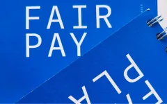 Blauer Hintergrund mit weißem Text "FAIR PAY".
