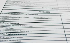 Tabellenkalkulation mit Ausgabenkategorien auf Deutsch und Englisch.