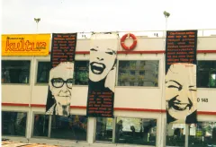 Fassade mit feministischen Bannern und gelbem Kulturlogo.