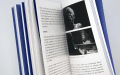 Offenes Buch mit Text und zwei Fotos von Personen in Schwarz-Weiß.